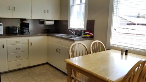 a kitchen with a table and chairs and a refrigerator at Forks Motel in Forks
