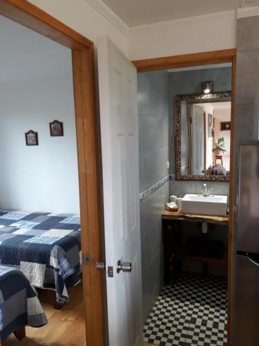 a bathroom with a sink and a bed and a mirror at Cabanas Viento Sur. Los Vilos in Los Vilos