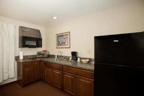 a kitchen with a sink and a black refrigerator at Forks Motel in Forks
