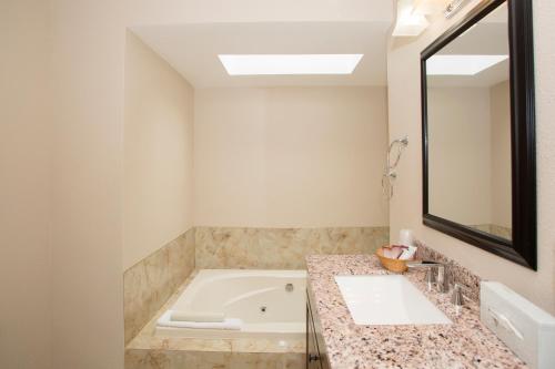 a bathroom with a tub and a sink and a mirror at Forks Motel in Forks