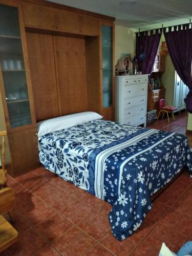 a bedroom with a bed with a blue and white blanket at O Pazo in O Grove