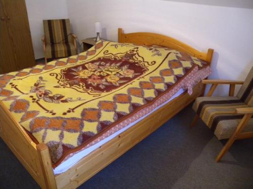 BalatonszentgyörgyにあるApartment Balatonszentgyorgy 3の木製ベッド(キルト付)が備わる客室です。