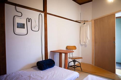 a bedroom with a bed and a table and a chair at Machicado in Tamano