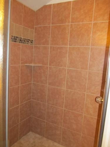a shower with a glass door and a tiled shower at The Remington Cabin in Wapiti