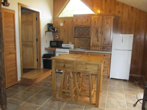 a kitchen with wooden cabinets and a white refrigerator at The Remington Cabin in Wapiti
