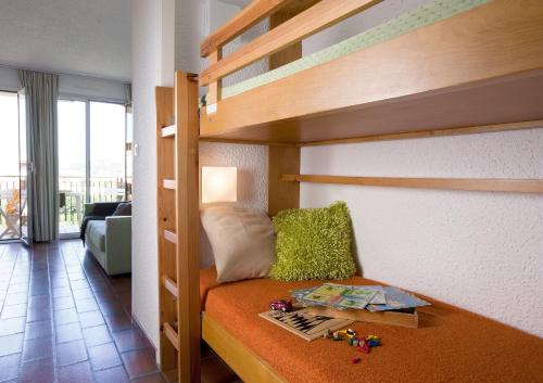 um pequeno quarto com um beliche e um livro em Résidence Pierre & Vacances Eden Parc em Saint-Tropez