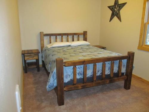 a wooden bed in a bedroom with a star on the wall at Mountain Man Cabin in Wapiti