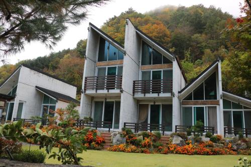 a building with windows and flowers in front of it at Moon on the Cloud in Yeongwol