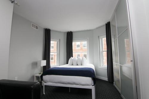 a bedroom with a bed and two windows at Stylish Studio on Newbury Street, #10 in Boston