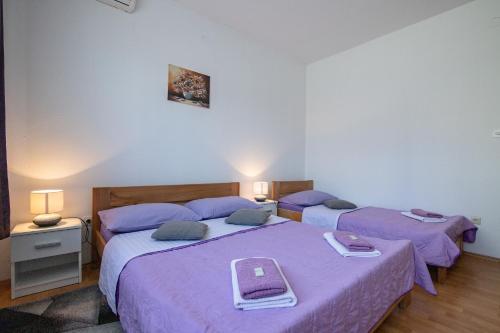 two beds in a room with purple sheets at Room Anton in Rakovica