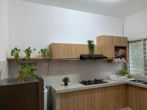 士毛月的住宿－甜蜜之家公寓，厨房配有木制橱柜和炉灶烤箱。