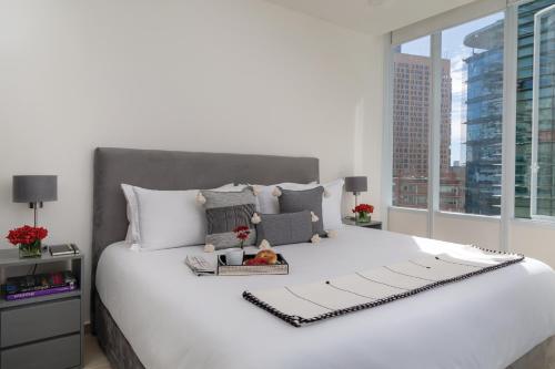 a bedroom with a large white bed with a window at Botticelli Tower By The Local Way in Mexico City