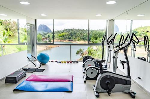 a gym with a large window and cardio equipment at Hotel Santa Maria de las Aguas Peñol in Guatapé