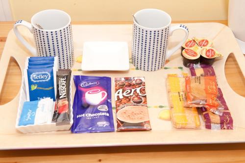 a tray with snacks and cups on a table at Holbrook Bed and Breakfast in Shaftesbury