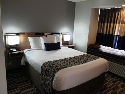 a hotel room with a large bed and a window at Microtel Inn & Suites by Wyndham Augusta/Riverwatch in Augusta