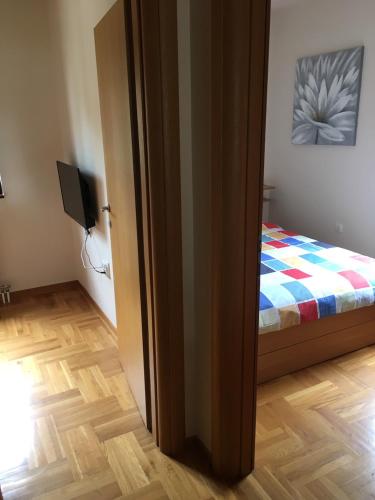 een kamer met een slaapkamer met een bed en een televisie bij Zlatibor Apartman Pantic in Zlatibor