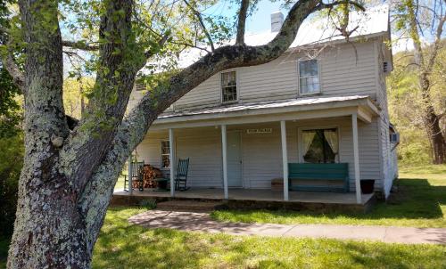an old white house with a tree in front of it at Graves Mountain Farm & Lodges in Syria