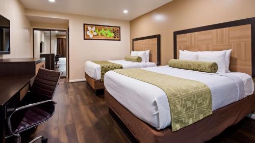 a hotel room with two beds and a desk at Best Western Plus Glendale in Glendale