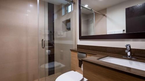 a bathroom with a toilet and a sink and a shower at Best Western Plus Glendale in Glendale