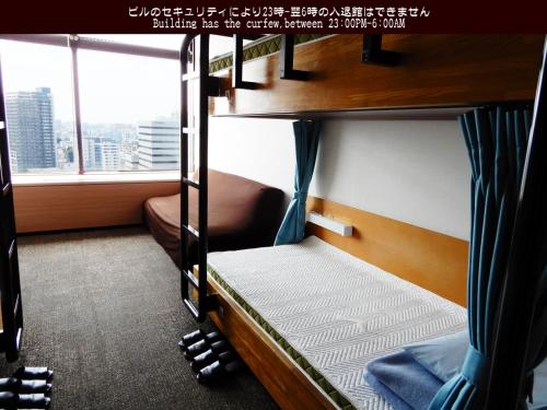 two bunk beds in a room with a window at Tokyo Central Youth Hostel in Tokyo