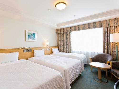 a hotel room with two beds and a window at Keio Plaza Hotel Hachioji in Hachioji
