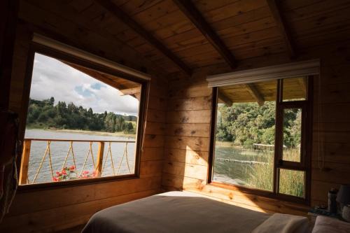 a bedroom with a window with a view of the water at Hermosa Cabaña en La Cocha-Finca INDIANA in El Encano