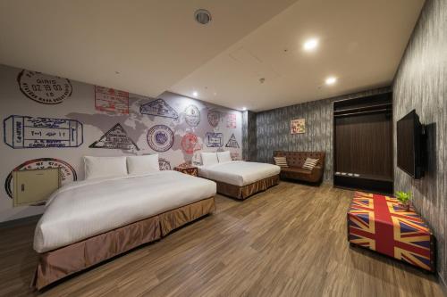 a hotel room with two beds and a television at Skyone Hotel in Kaohsiung