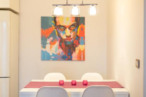 a dining room with a table and a painting on the wall at VF Kragujevac Apartments in Kragujevac