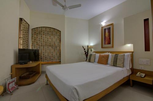 a bedroom with a large bed and a television at Tristar Serviced Apartments in Bengaluru