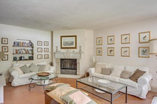 a living room with two white couches and a fireplace at Torre del Falco in Spoleto