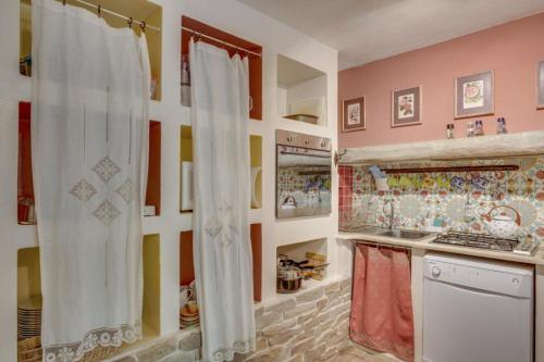 a kitchen with colorful walls and a white curtain at Torre del Falco in Spoleto