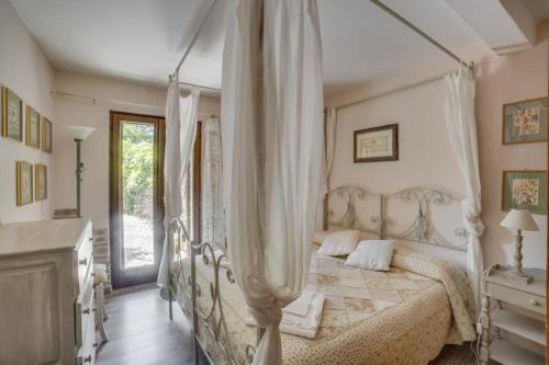 a bedroom with a white bed with a canopy at Torre del Falco in Spoleto