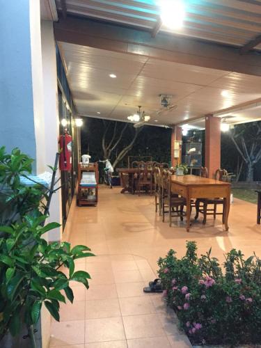 a patio with tables and chairs and a dining area at Poon Suk Hotel Kabin Buri in Kabin Buri