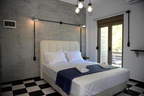 a bedroom with a bed with two towels on it at Candy's Boutique Rooms in Asprovalta