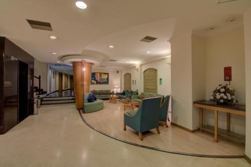 a lobby with chairs and a couch and a table at Tristar Serviced Apartments in Bangalore