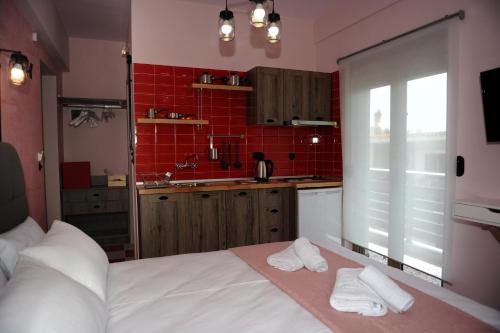 a bedroom with a large white bed and red tiles at Candy's Boutique Rooms in Asprovalta