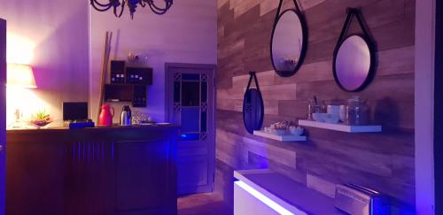 La salle de bains est pourvue de 2 miroirs sur un mur en bois. dans l'établissement Les Cloches de Corneville, à Corneville-sur-Risle