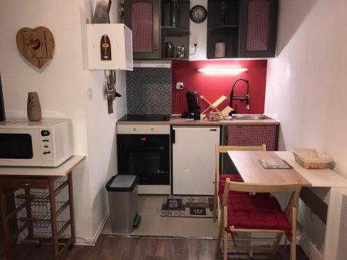 une petite cuisine avec une table et un micro-ondes dans l'établissement studio saint lary au pla d'adet, à Saint-Lary-Soulan