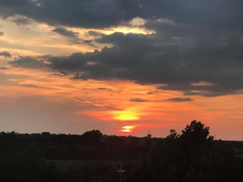 a sunset with the sun setting in the sky at The Bell Tower Lodge in Palidoro