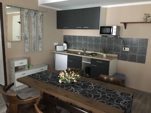 a kitchen with a table and a kitchen with a sink at Pension zur Schmied'n in Marzling