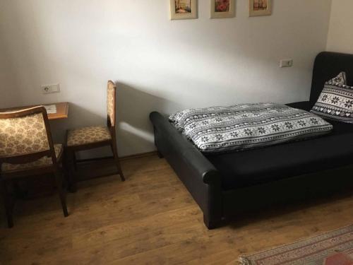 a bedroom with a bed and a chair and a table at Pension zur Schmied'n in Marzling