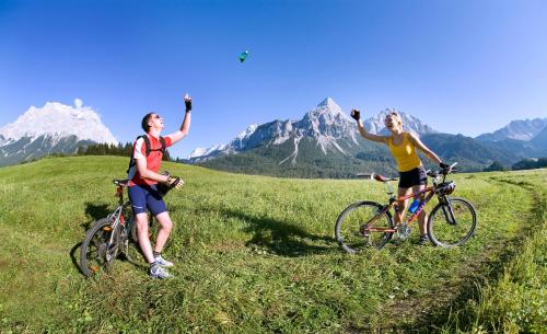 two women standing on a hill with their bikes at am Mühlbach - Ferienwohnungen Luttinger in Bichlbach