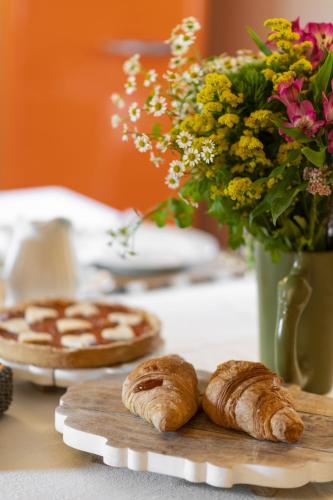 a table with pastries and flowers and a vase of flowers at Baldovino b&b in Villamagna