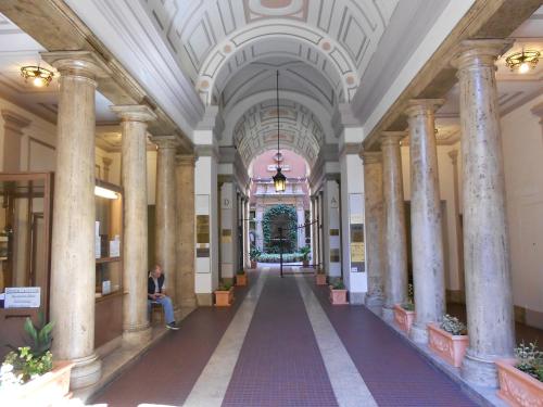 a person sitting in the middle of a hallway in a building at Matisse Royal in Rome