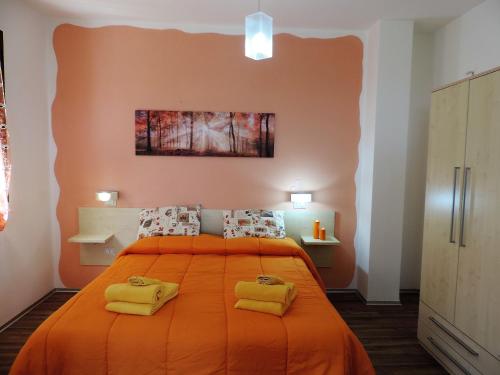 a bedroom with an orange bed with two yellow pillows at Residenza Belvedere in Orosei