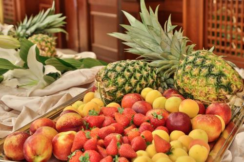 a tray of fruit on a table with pineapples and apples at Best Western Classic Hotel in Reggio Emilia