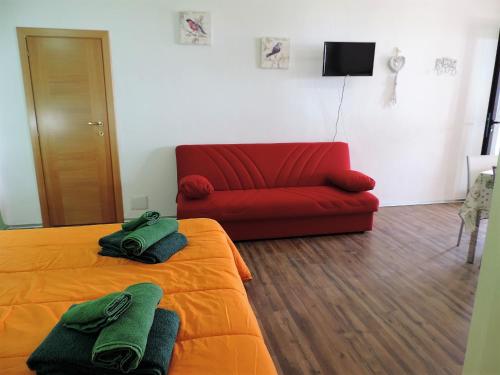 オロゼーイにあるResidenza Belvedereのベッドと赤いソファが備わる客室です。