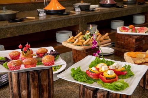 a buffet line with plates of food and appetizers at Regenta Central Cassia Zirakpur Chandigarh in Chandīgarh