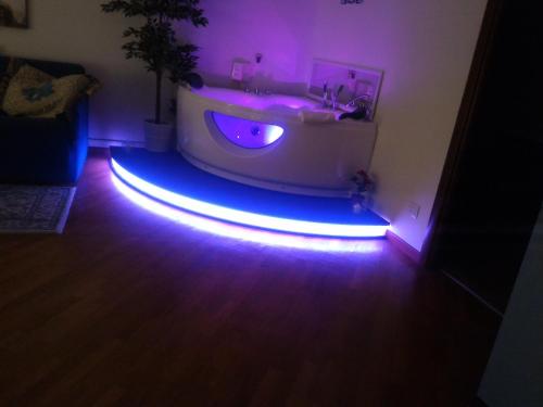 a bathroom with a tub and a sink with purple lights at Hotel Youri Il Magnifico in Genova