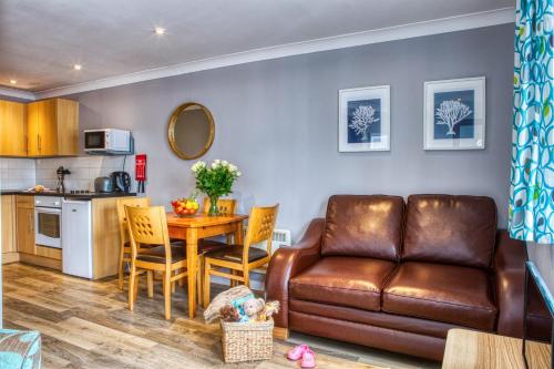 a living room and kitchen with a couch and a table at Newlands Holidays in Bridport